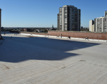 Plainville commercial roofing project with flat roof and city skyline in the background.